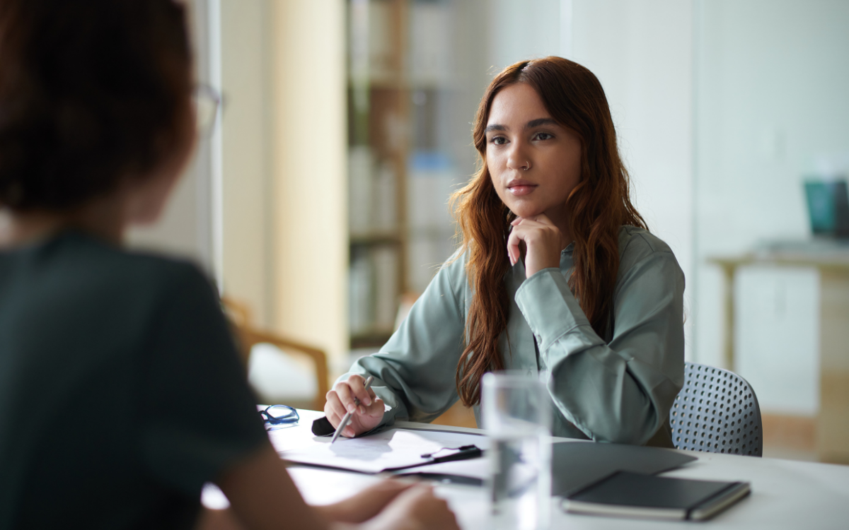 Employee experience a manager and their direct report in a meeting together